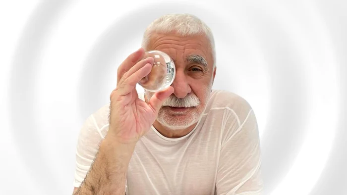 Adrian Sârbu privind printr-un glob de sticlă