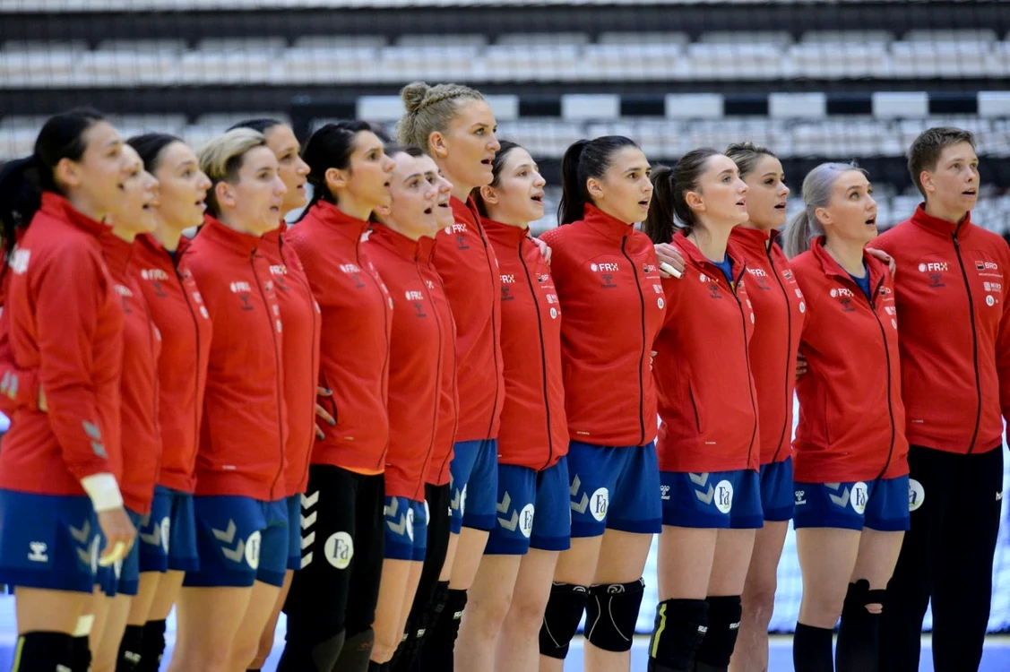 Echipa feminină de handbal a României intonând imnul într-un meci oficial