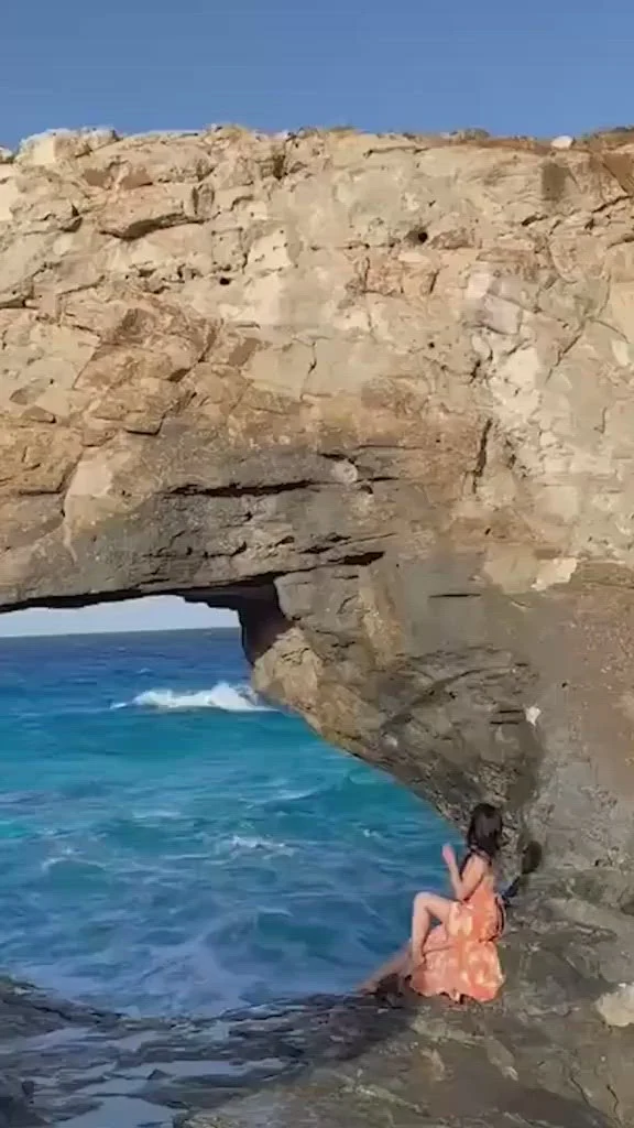 Turistă la un pas de a-și pierde viața după ce a fost luată de un val uriaș în timp ce poza pe o stâncă periculoasă