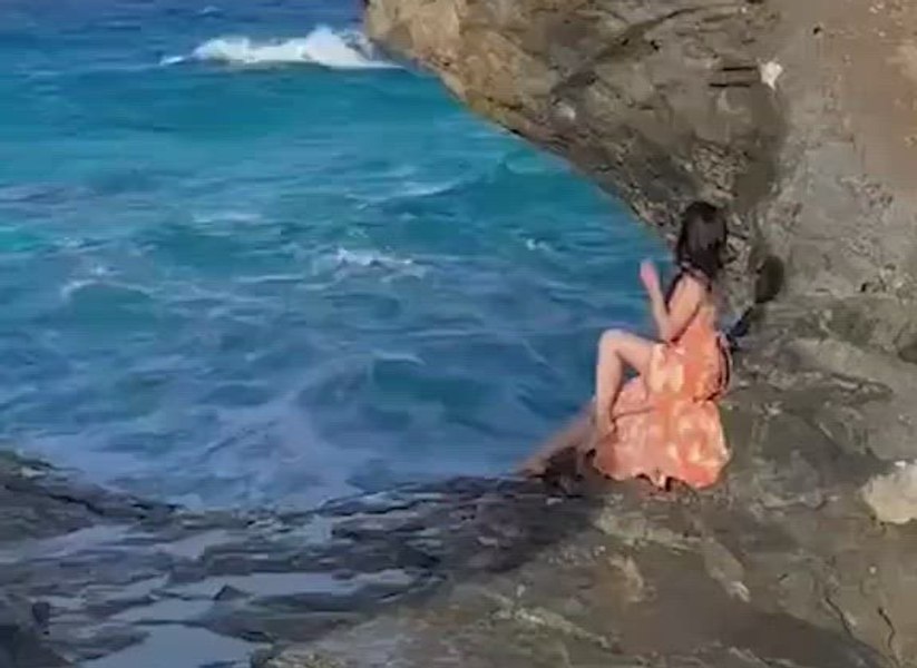 Turistă la un pas de a-și pierde viața după ce a fost luată de un val uriaș în timp ce poza pe o stâncă periculoasă