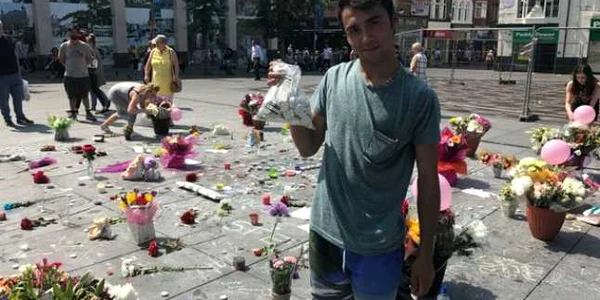 Un roman are grija de florile si lumanarile depuse in Piata Williamson din Liverpool in memoria victimelor de la Manchester FOT The Liverpool Echo