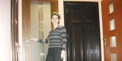 O angajată a unui magazin prezintă mai multe modele de uşi