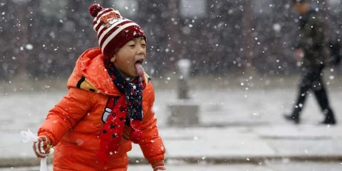 Un băieţel se joacă în ninsoare la palatul Gyeongbok din Seul Coreea de Sud FOTO AP