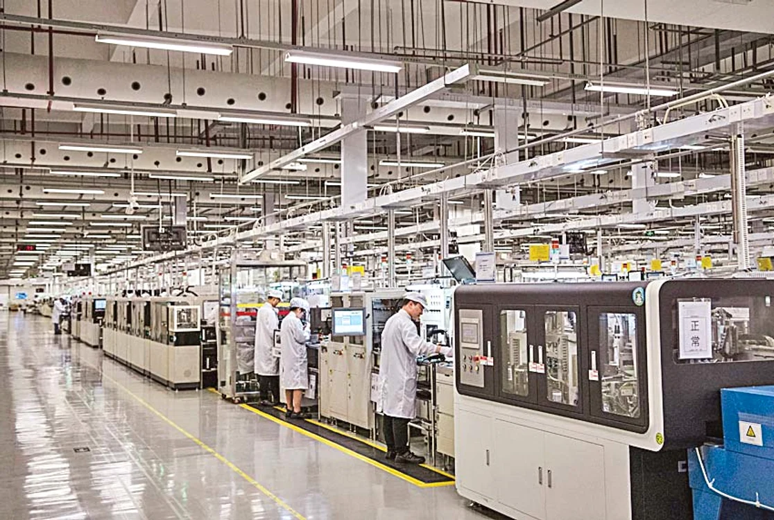 Munca la linia de producție se face sub o lumină aspră, albă și în tăcere absolută