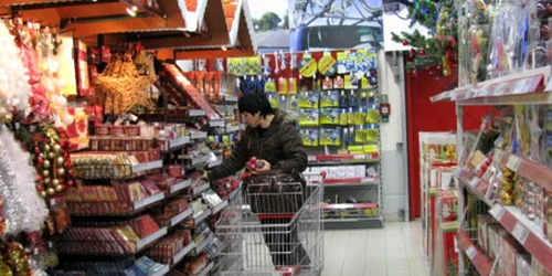 O băcăuancă alege din rafturile unui centru comercial din oraş ornamentele pe care le va folosi pentru împodobirea bradului