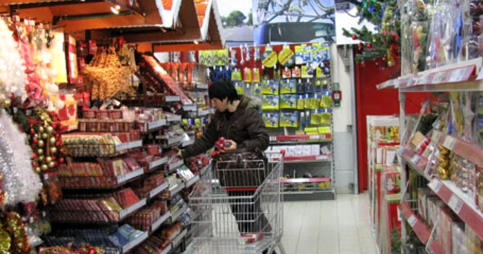 O băcăuancă alege din rafturile unui centru comercial din oraş ornamentele pe care le va folosi pentru împodobirea bradului