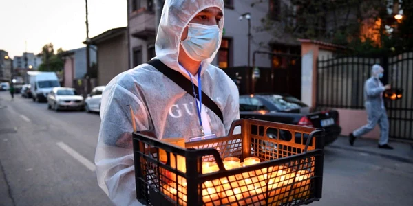 Voluntar împărţind lumină de Paşti FOTO AFP/ Daniel Mihăilescu