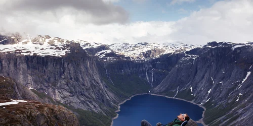 Turist pe malul unui lac din Norvegia Sursa freepik com jpg