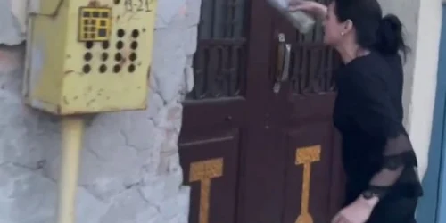 Femeia aruncă cu urină pe poartă FOTO