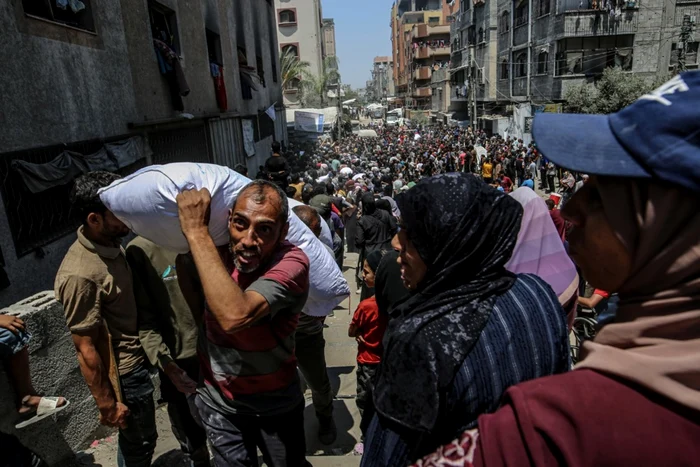 Palestinieni strămutați așteaptă să primească ajutoare umanitare în Gaza City FOTO EPA-EFE