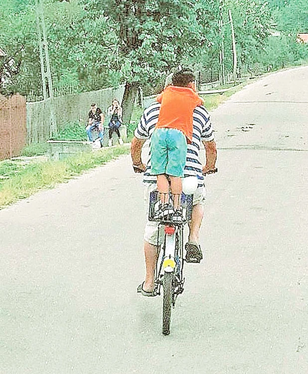 Bodo își plimbă băiatul  cel mare cu bicicleta