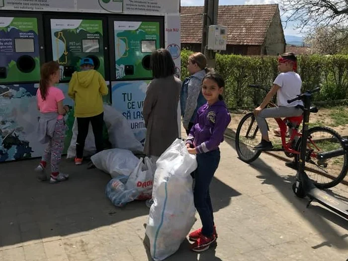 Copii din Șpring, cu sacii de PET-uri la aparatul de reciclat FOTO Iulia Stănilă