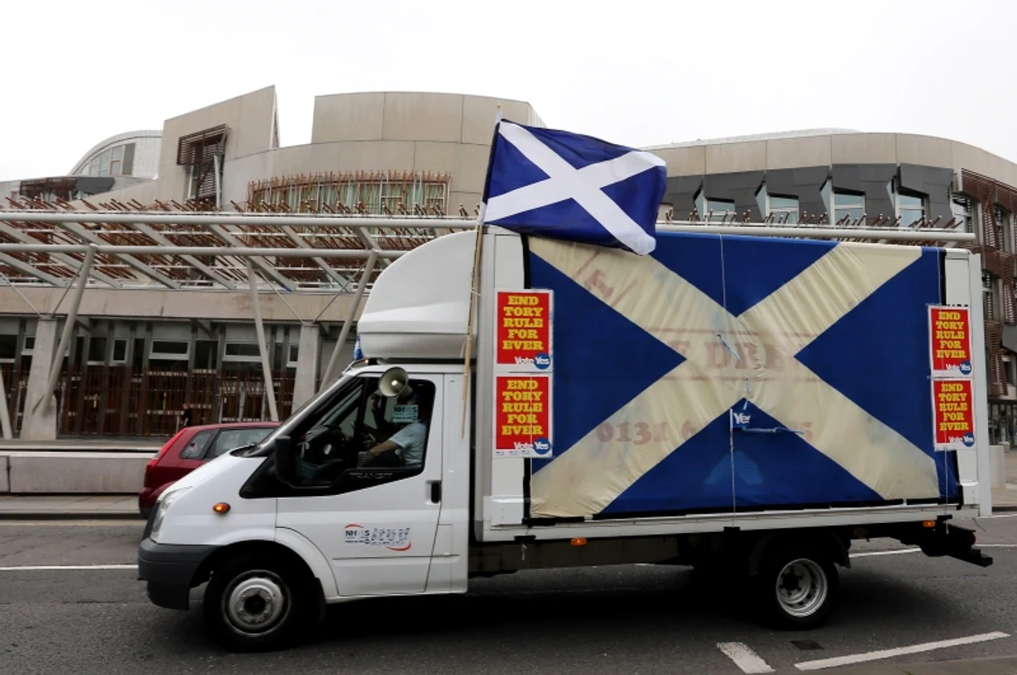 O dubă cu steagul Scoţiei trece prin faţa Parlamentului din Edinburgh. Campania pentru independenţă este extrem de vocală, dar rezultatul ar putea fi la limităFoto: AP