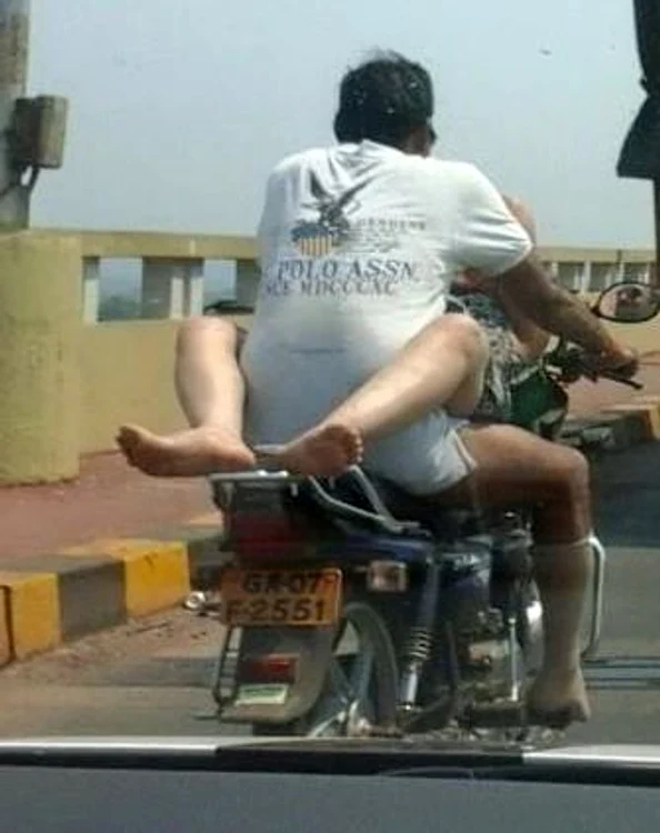 
    Bărbatul de pe motocicletă poartă doar un tricou și o pereche de șosete, în timp ce femeia are picioarele încolăcite în jurul luifoto: Facebook/Vishnu Surya Wagh  