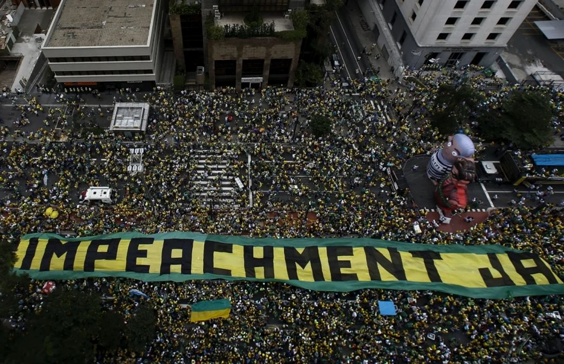 Protestatari din Sao Paulo desfăşurând un banner imens cu mesajul „Da suspendării”, lângă două păpuşi imense reprezentându-i pe preşedintele Rousseff şi fostul preşedinte Lula da Silva (îmbrăcat în uniformă de închisoare) FOTO AFP/Getty Images