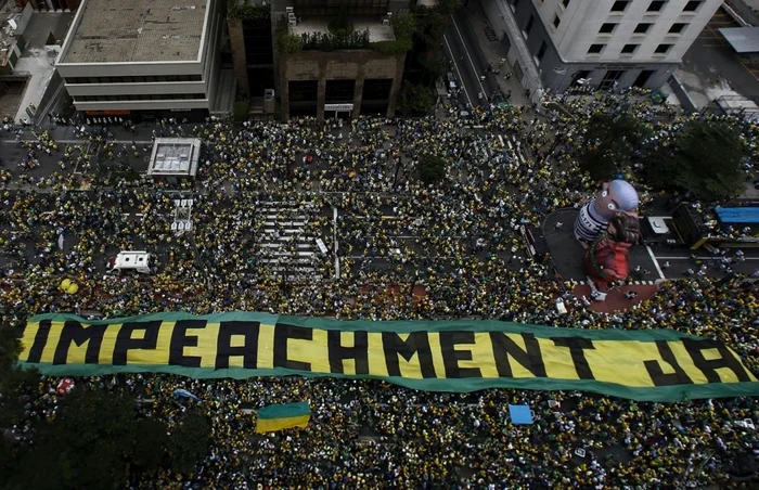 Protestatari din Sao Paulo desfăşurând un banner imens cu mesajul „Da suspendării”, lângă două păpuşi imense reprezentându-i pe preşedintele Rousseff şi fostul preşedinte Lula da Silva (îmbrăcat în uniformă de închisoare) FOTO AFP/Getty Images