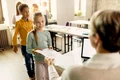 elementary students taking their test results from teacher classroom jpg