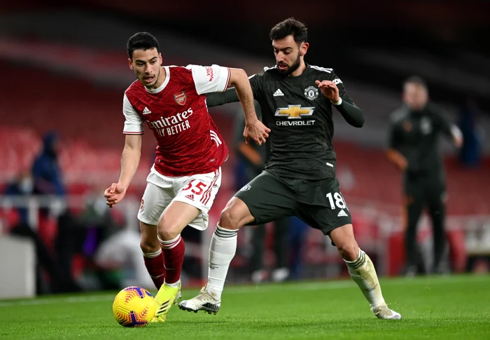 
    Gabriel Martinelli și Bruno Fernandes își dispută balonulFoto: Guliver / GettyImages  