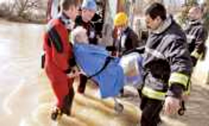 O bătrână din Chatellaillon (vestul Franţei) este evacuată din casa inundată
