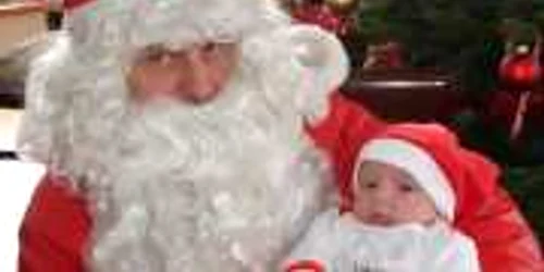 Un Crăciunel costumat aşteaptă cadourile de la Moşul cu barbă