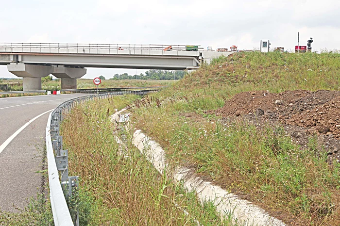  Muncitorii montează barele de protecţie şi pun stâlpii de iluminat pe pasajul car  supratraversează Centura 