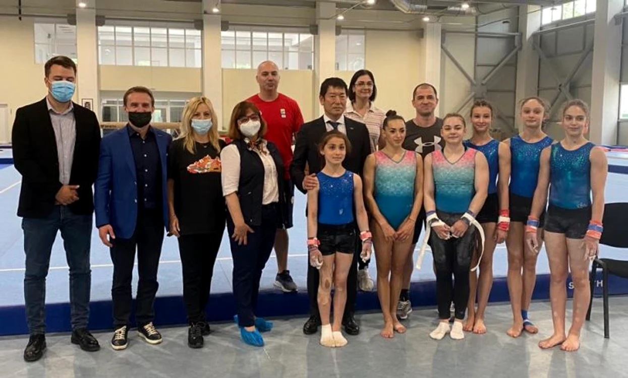 
    Președintele Federației Internaționale de Gimnastică, alături de sportive și antrenori  