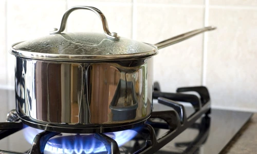 A stainless steel pot on a gas stove jpeg