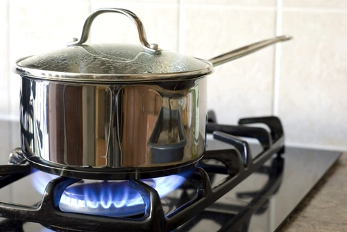 A stainless steel pot on a gas stove jpeg