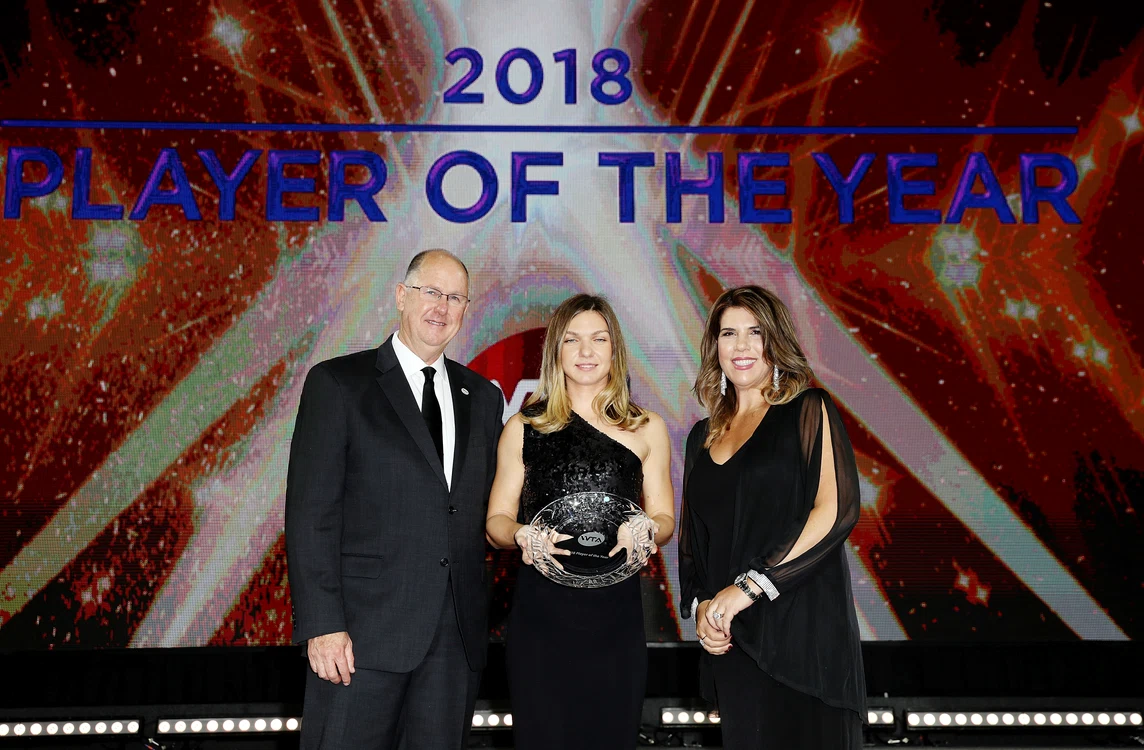 
    Simona Halep a primit trofeul de la fosta campioană Jennifer Capriati și de la șeful WTA Steve SimonFoto: Guliver / GettyImages  