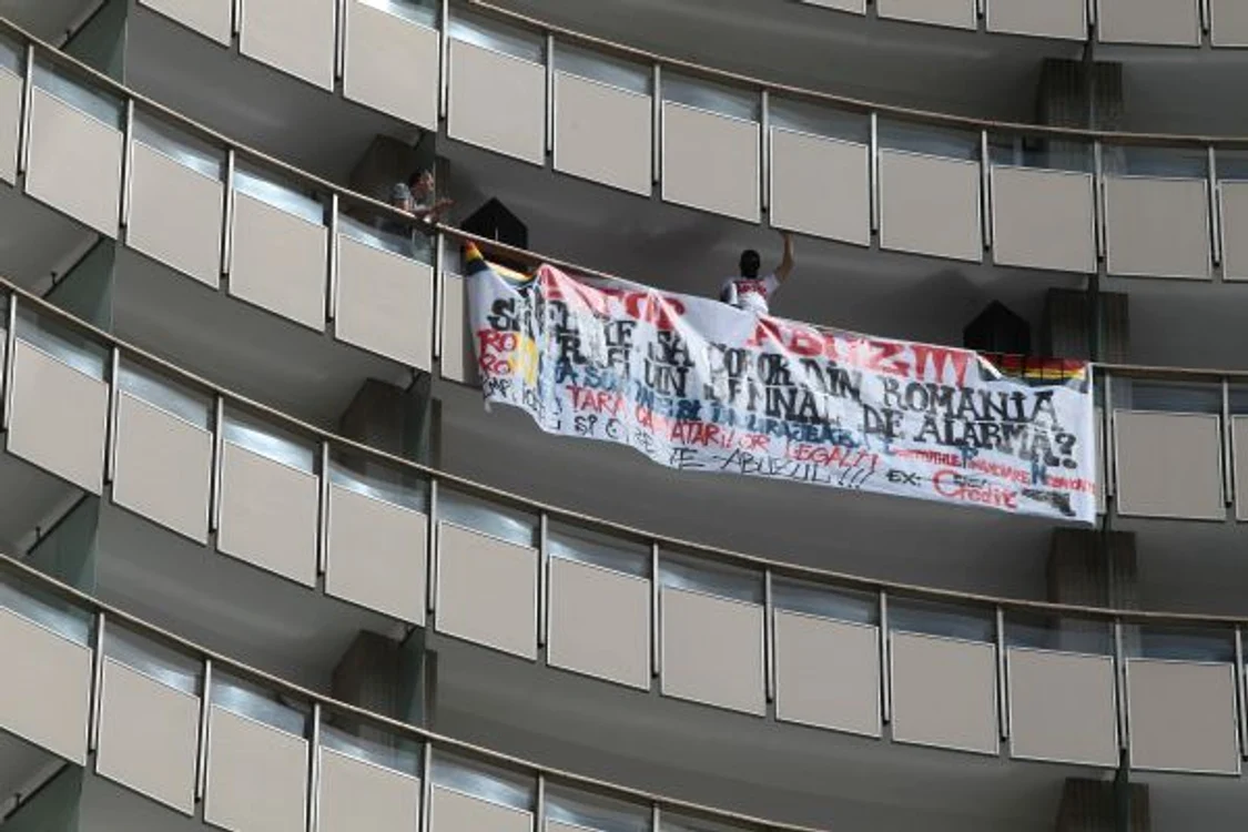 Bărbatul a pus un banner pe balconul la care se află
