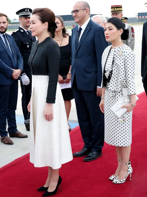 Suthida alături de fiica sa vitregă, la aterizarea în Franța