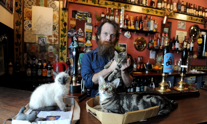 Proprietarul Bag of Nails, Luke Daniels, alături de pisicile din barul lui