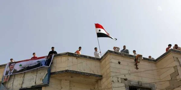 Sustinatori ai lui Bashar al-Assad flutura steagul Siriei pe o cladire eliberata recent FOTO EPA-EFE