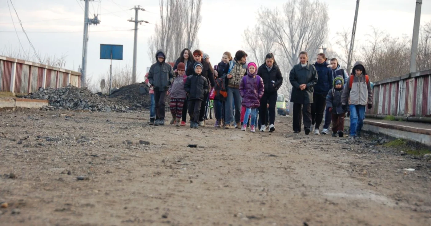 Elevii merg în pas de marş pe un pod dezafectat către şcoală FOTO: Mădălin Sofronie