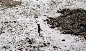 Imagine din 2004 cu un bărbat din tribul sentinelez își îndreaptă arcul și săgeata spre un elicopter al Gărzii de Coastă indiene FOTO AFP