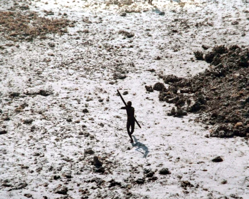 Imagine din 2004 cu un bărbat din tribul sentinelez își îndreaptă arcul și săgeata spre un elicopter al Gărzii de Coastă indiene FOTO AFP