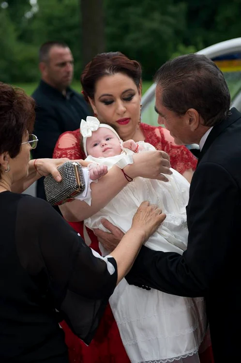 Oana Roman, Marius Elisei şi fetiţa lor, la botez. Petre şi Mioara Roman au fost şi ei prezenţi la evenimentFoto: Facebook