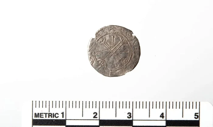 Pe fața vizibilă a monedei apare un motiv numit „cruce peste cruce” (© Arkeologisk Museum, Universitetet i Stavanger)