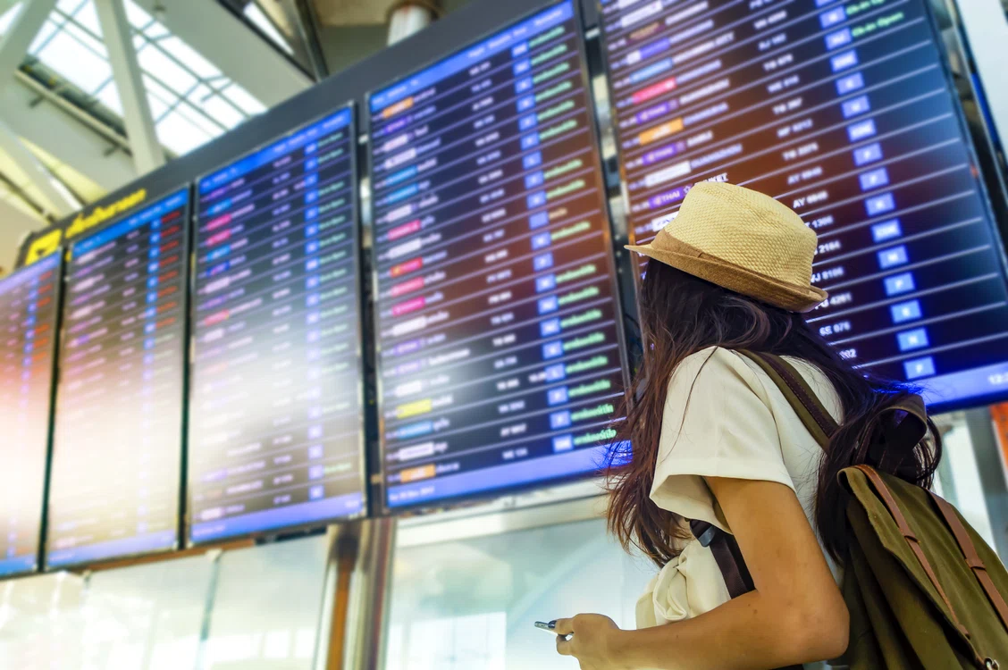 Turist uitându-se la afișajul dintr-un aeroport