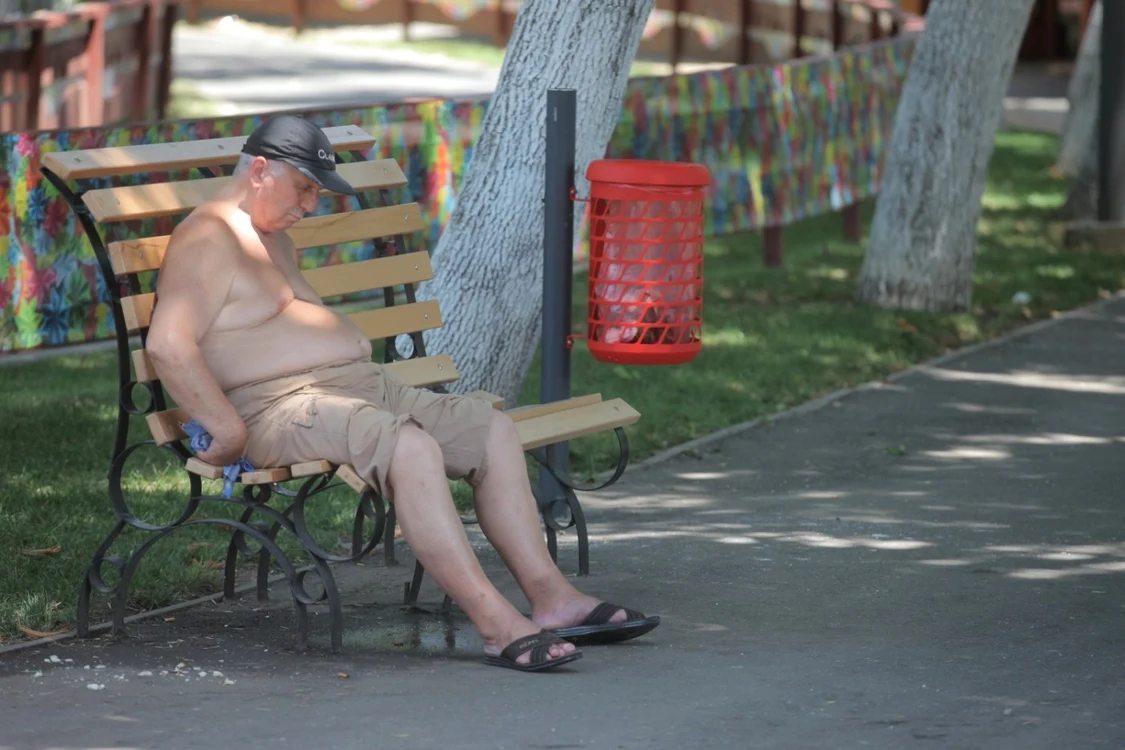 Bărbat pe bancă afectat de căldură