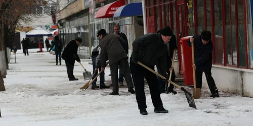 Oamenii muncesc de zor la îndepărtarea primului strat de gheaţă
