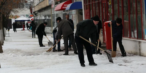 Oamenii muncesc de zor la îndepărtarea primului strat de gheaţă