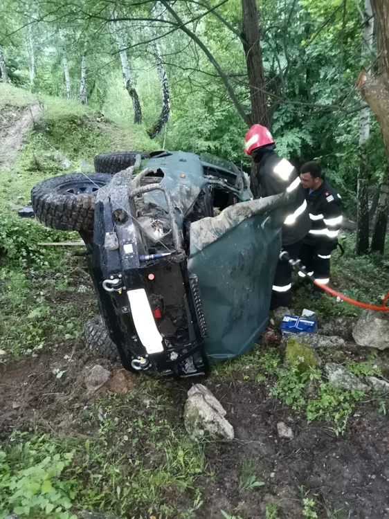 Pompierii au găsit autoturismul răsturnat pe o parte, cu un cablu de energie electrică înfăşurat în jurul caroseriei şi cu un bărbat de cca 20 de ani încarcerat în acesta. FOTO: ISU Cluj