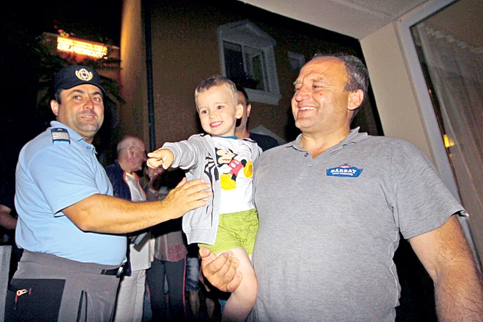 Tatăl, în al nouălea cer: după 12 ore, îşi poate ţine din nou puştiul în braţe. Din imagine nu putea lipsi jandarmul care l-a găsit pe băieţel