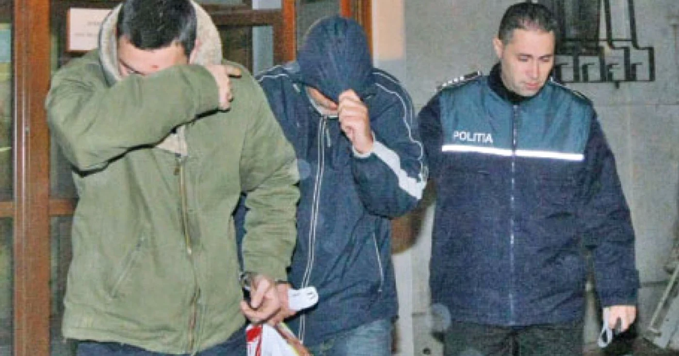 Cei doi poliţişti (cu feţele acoperite) au fost arestaţi pentru 29 de zile  