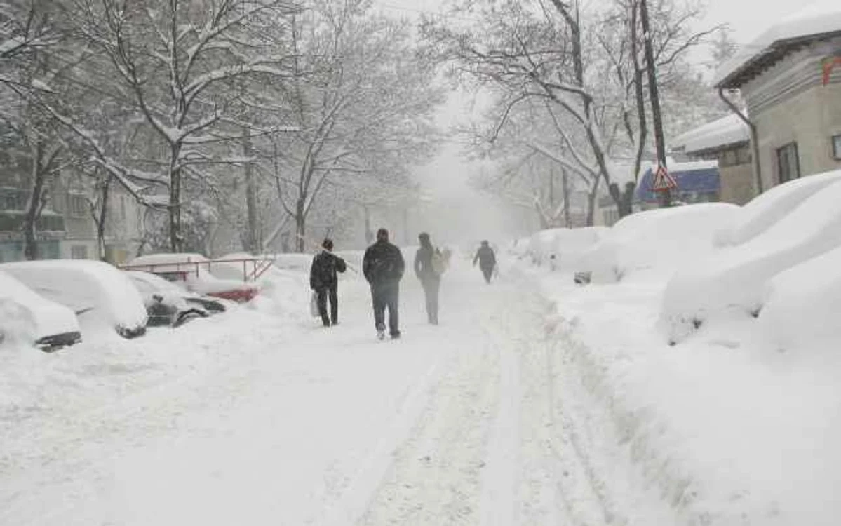 Pietonii merg pe stradă fiindcă trotuarele sunt îngropate în zăpadă