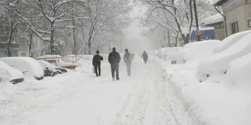 Pietonii merg pe stradă fiindcă trotuarele sunt îngropate în zăpadă