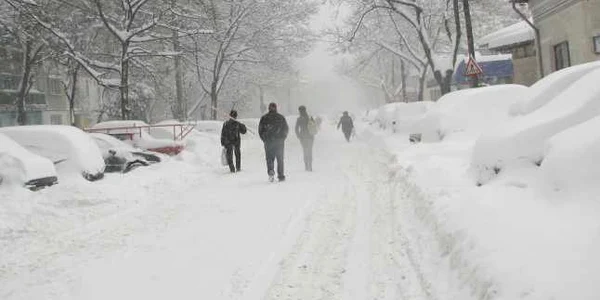 Pietonii merg pe stradă fiindcă trotuarele sunt îngropate în zăpadă