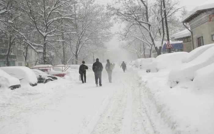 Pietonii merg pe stradă fiindcă trotuarele sunt îngropate în zăpadă