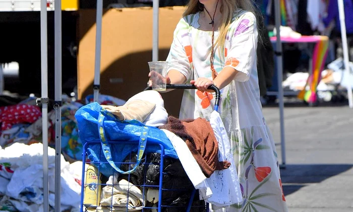 EXCLUSIVE: Drew Barrymore drinks a tall can of Coors beer as she pushes a cart full of clothes through a local flea market jpeg